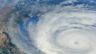 Satellite view of tropical cyclone showing swirling cloud formation and eye of storm illustrating health impacts and disaster risk